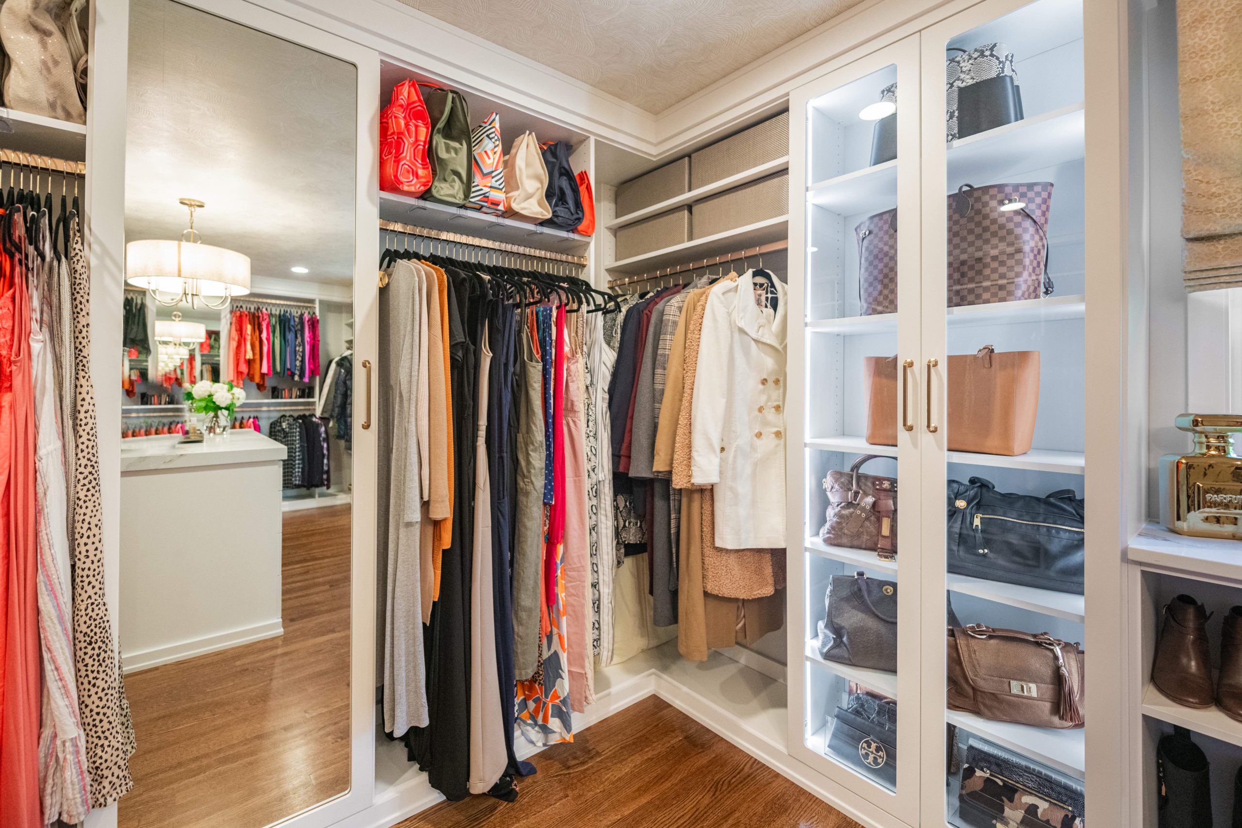 Enclosed closet cabinetry with glass Enclosed cabinetry in custom closet design.